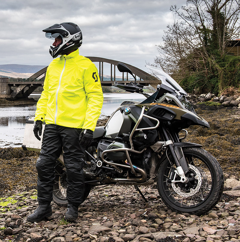 Guy wearing Scott waterproof jacket and pant next to BMW GS